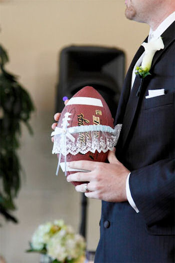 Groom holding football
                    with garter on it