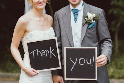 Couple holding thank you boards