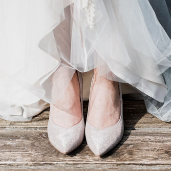 Bridal shoes
                  beneath wedding gown hem