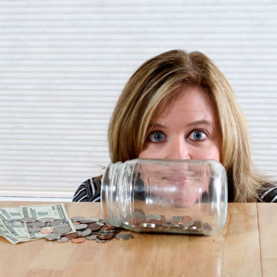 woman
                      looking at jar of money