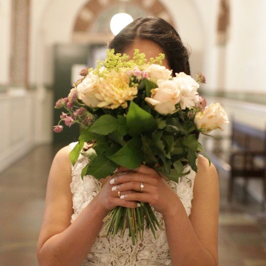 Bride hiding her face behin her bouquet