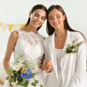Two
                      brides with eyes closed holding hands