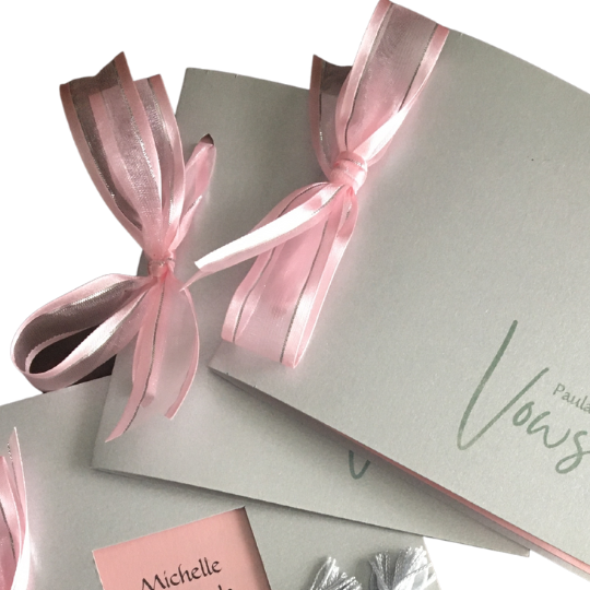 Silver gray
                      and vows cards tied with pink ribbon