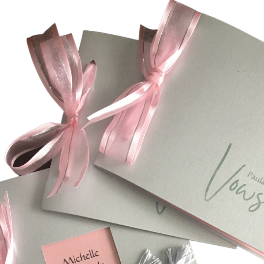 Silver gray
                      and vows cards tied with pink ribbon