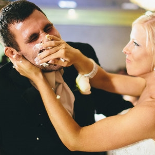 Bride smashing cake into groom's face