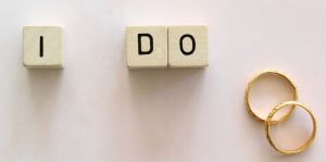 Two gold wedding
                      rings and alphabet blocks spelling out I DO