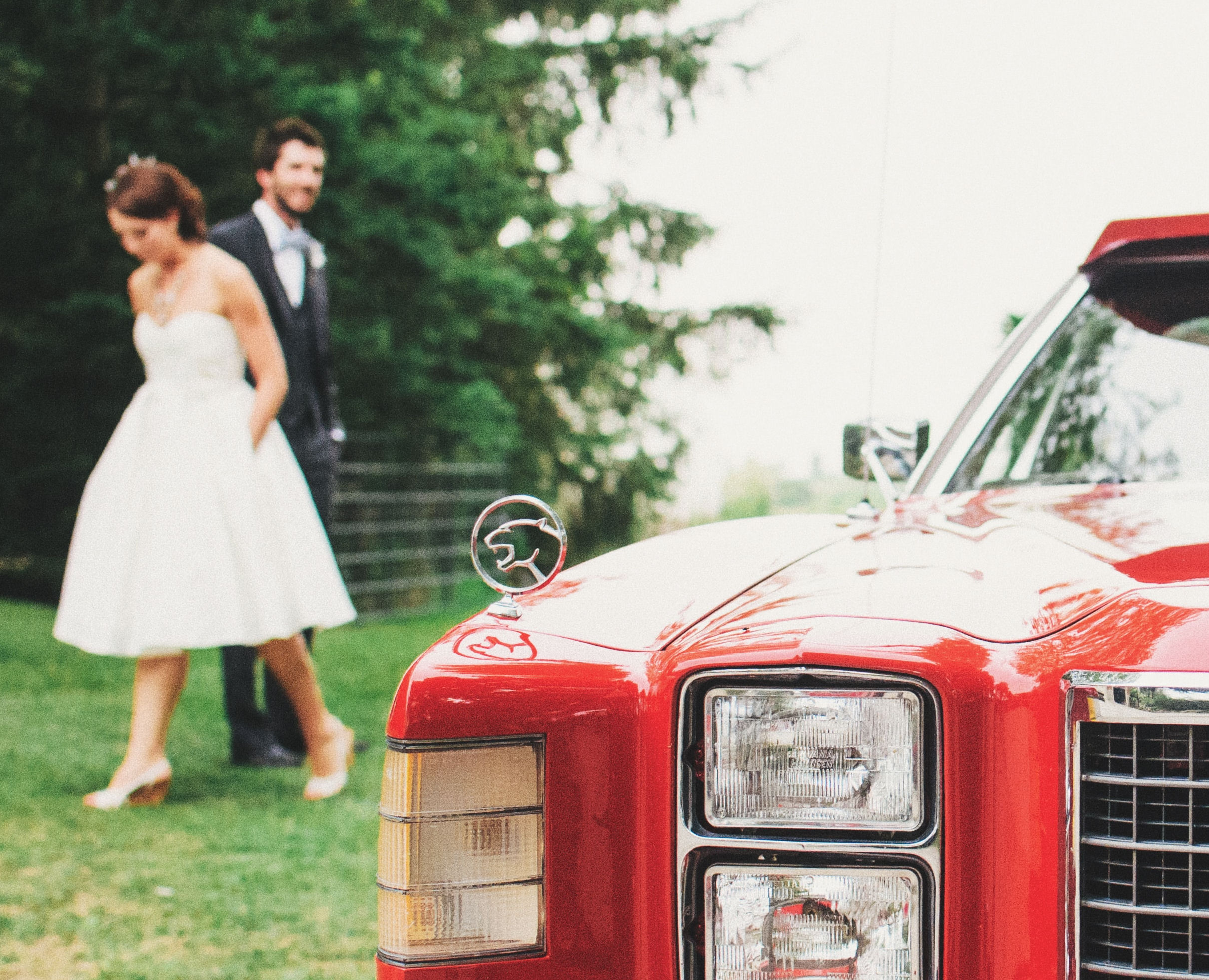 First Look groom behind bride with red
car