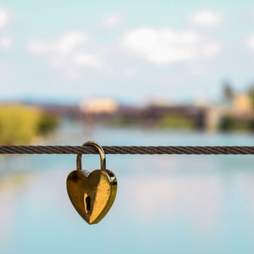 Love lock hanging on a bridge over a river