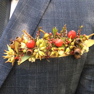 Pocket posy made of Australian
                              native flowers and gumnuts and succulents
                              in autumn tones