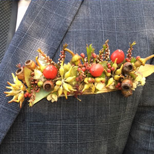 Pocket posy made of Australian
                              native flowers and gumnuts and succulents
                              in autumn tones