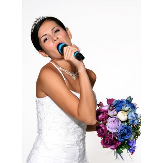 Bride,
                      singing into a hand held microphone. She is
                      wearing a white strapless dress and is holding a
                      multicoloured bouquet of flowers