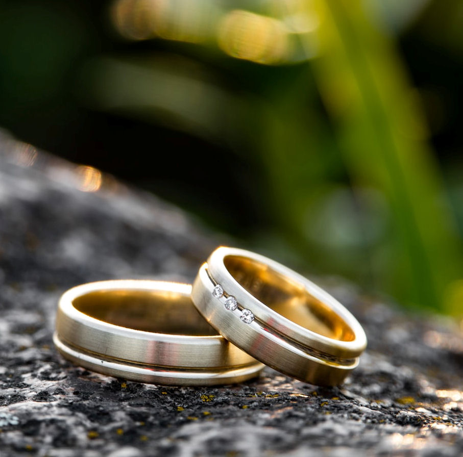 Gold wedding rings on
                      grey rock
