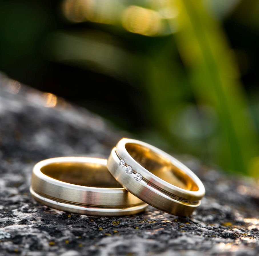 Gold wedding rings on
                      grey rock