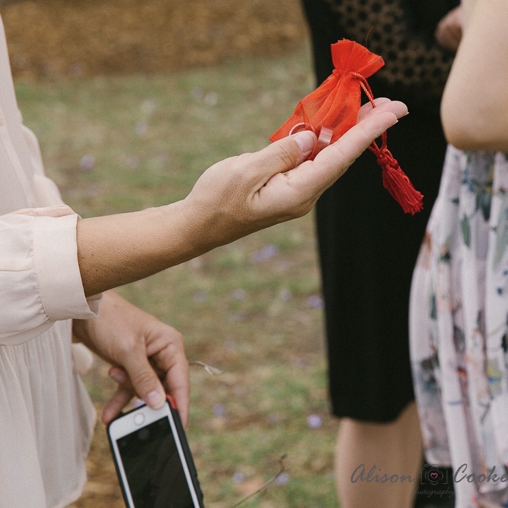 Guest holding wedding rings in a red bag