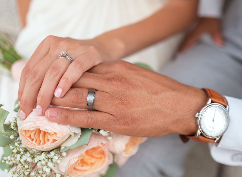 Marrying couple hands wearing rings with
                      watch