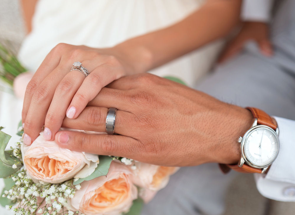 Marrying couple hands wearing rings with
                      watch