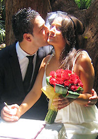 Gulay and Fabrizio sign the register after being
                  married by Jennifer Cram, Brisbane Marriage Celebrant