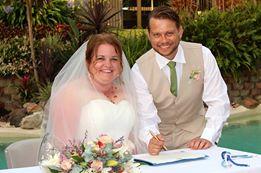 Kim and
                        Adam signing their certificate after their
                        surprise wedding at Brookfield